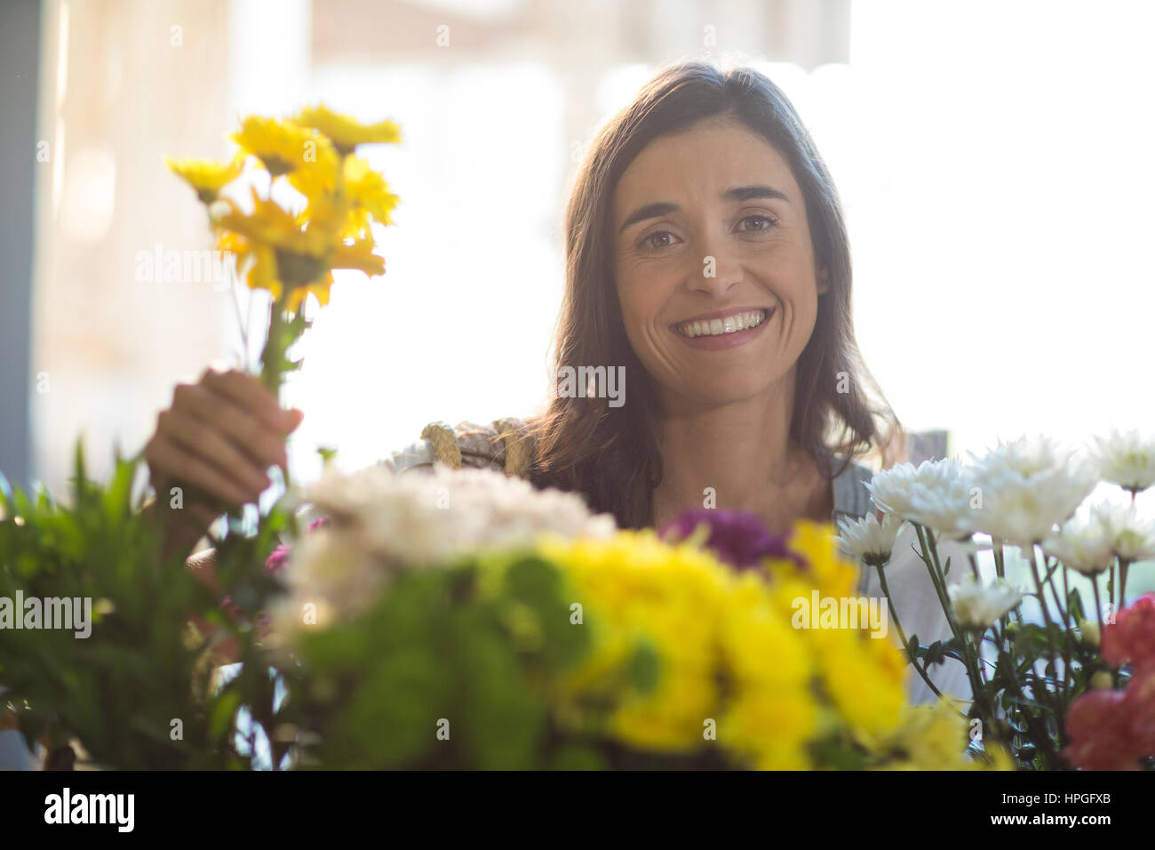 Portrait of a smiling woman holding a bunch of flowers at florist shop Stock Photo