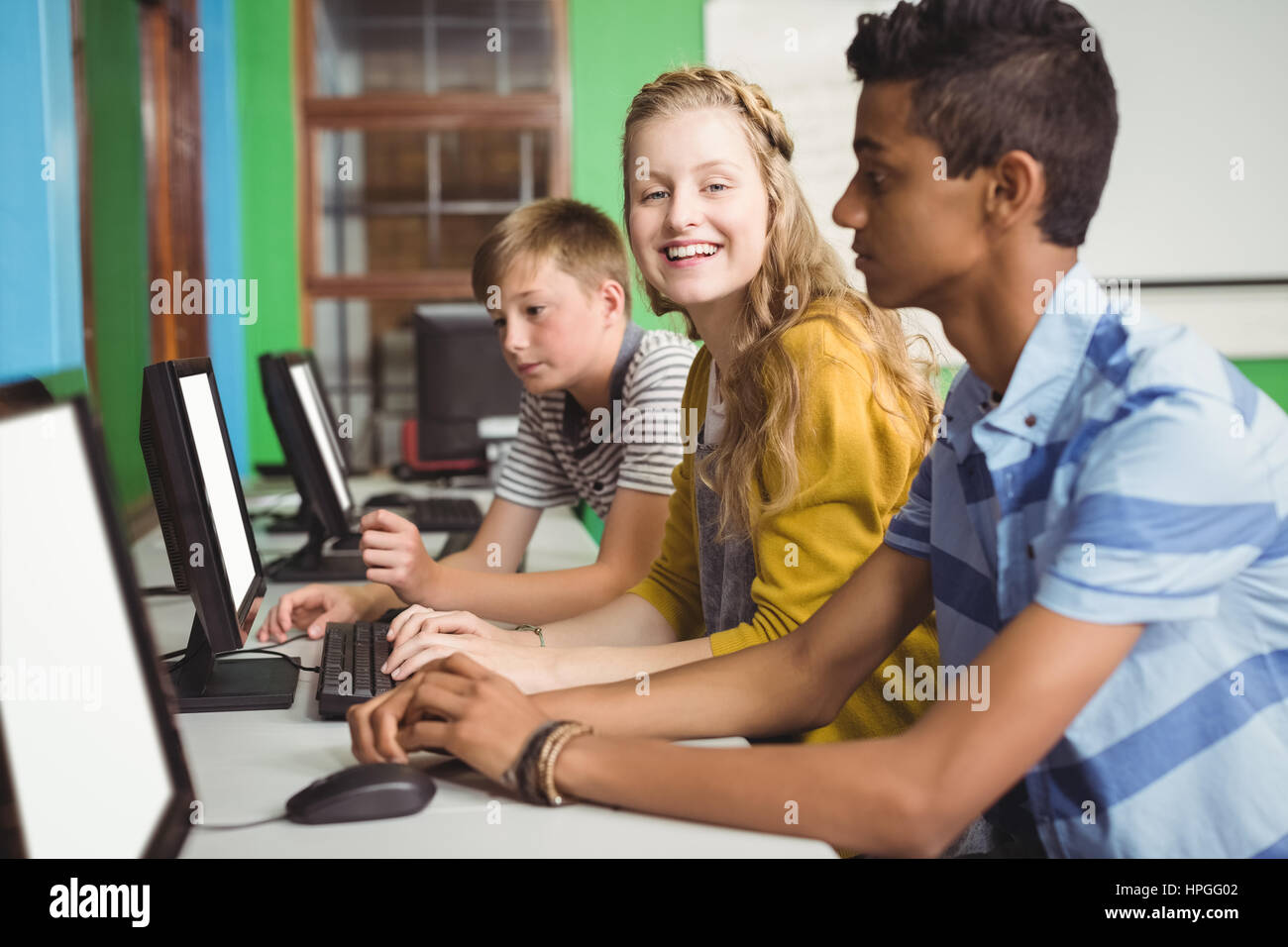 Smiling students studying in computer classroom at school Stock Photo ...