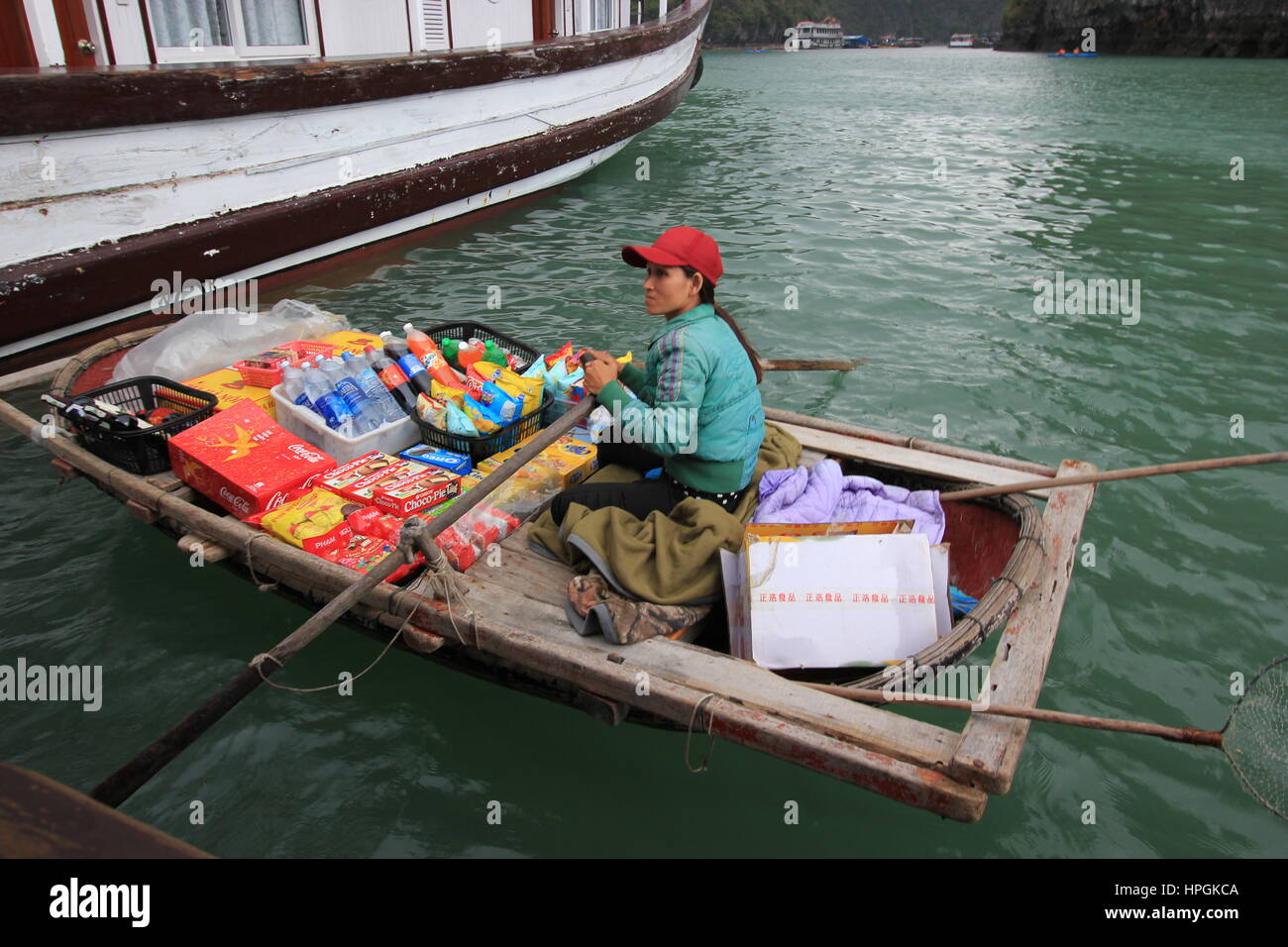 A Fisherwoman sells products to tourists in Halong Bay, Vietnam Stock Photo