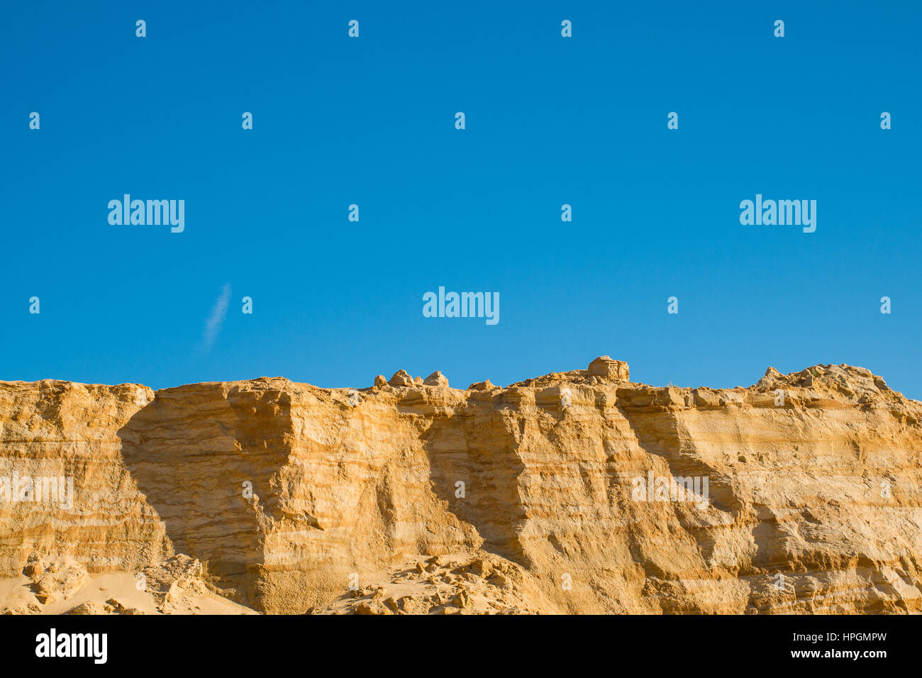 cliff of the yellow orange brown sand soil clay under the bright sunny ...