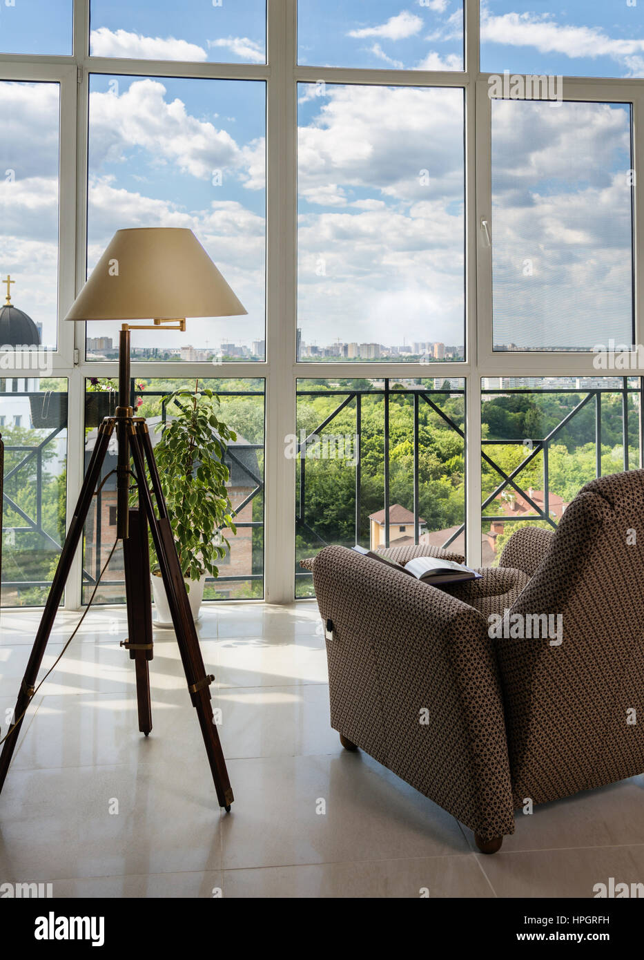 Armchair and lamp in front of the panoramic window Stock Photo