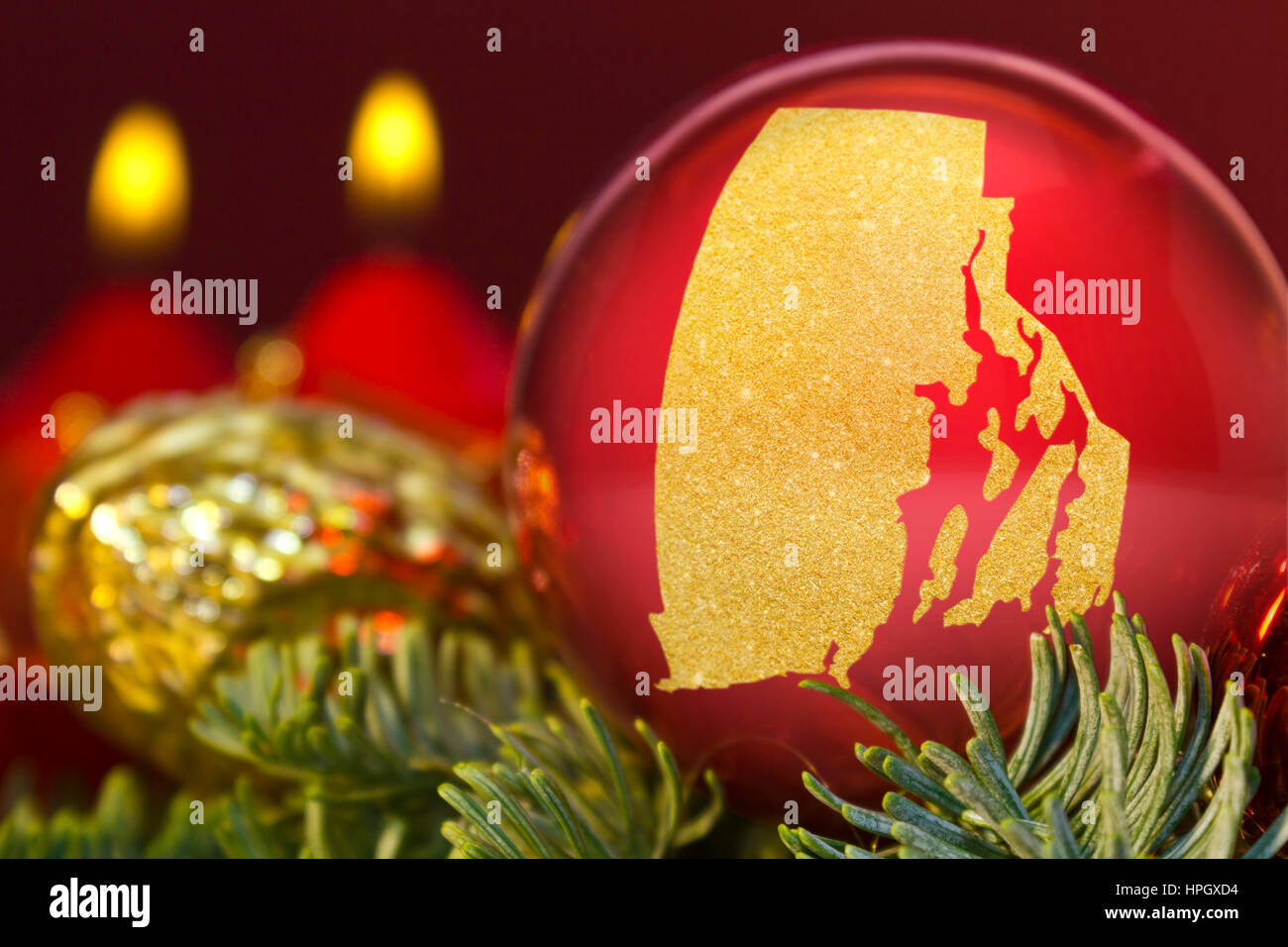 A glossy red bauble with the golden shape of Rhode Island.(series) Stock Photo