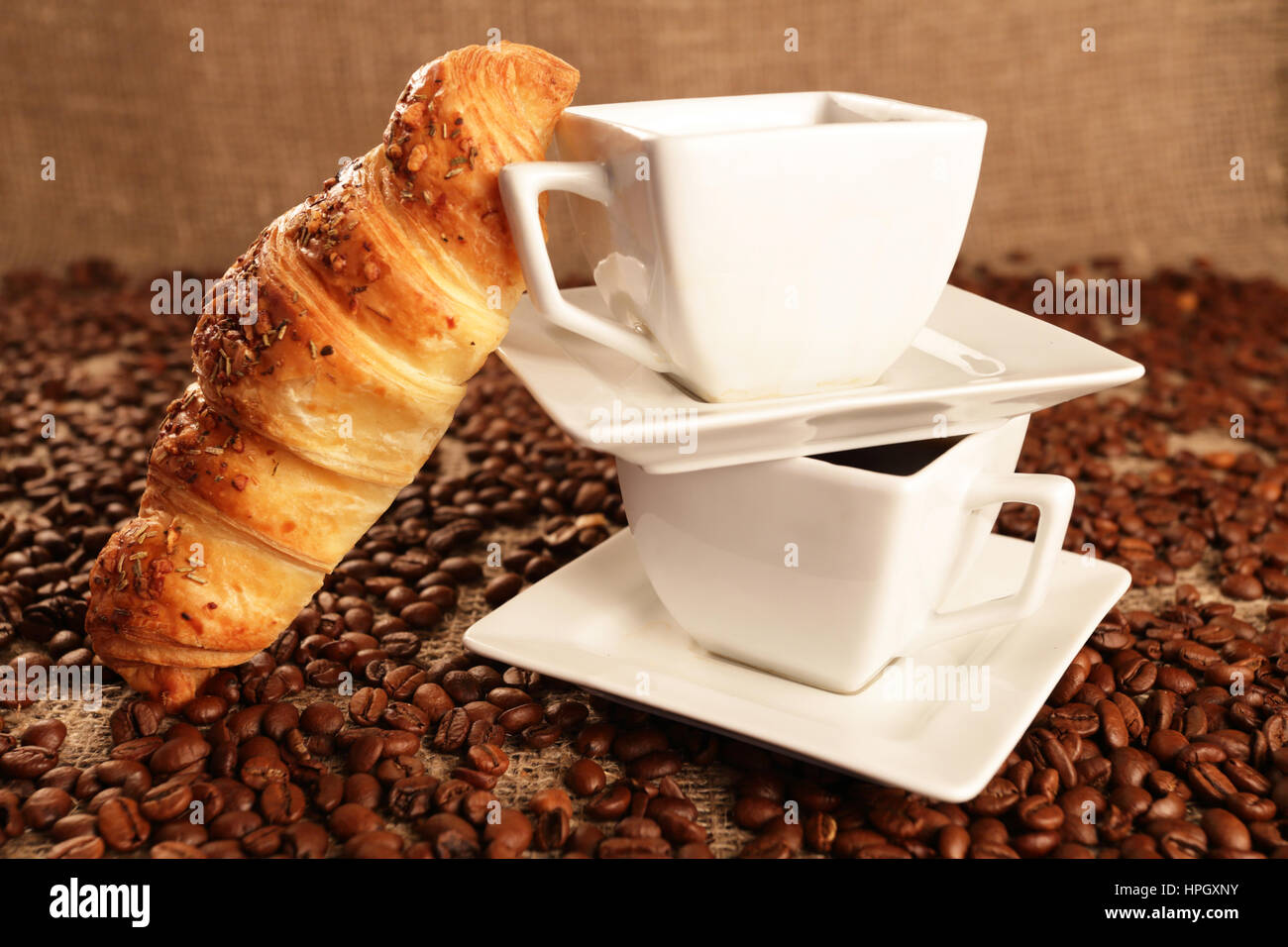 Coffee beans and tasty croissant on texture background Stock Photo