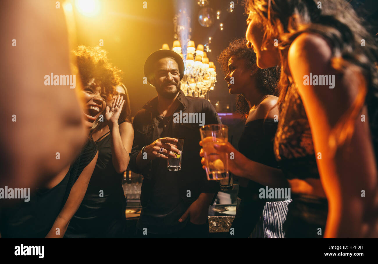 Image group of friends enjoying a party at pub. Happy young people having fun at nightclub. Stock Photo
