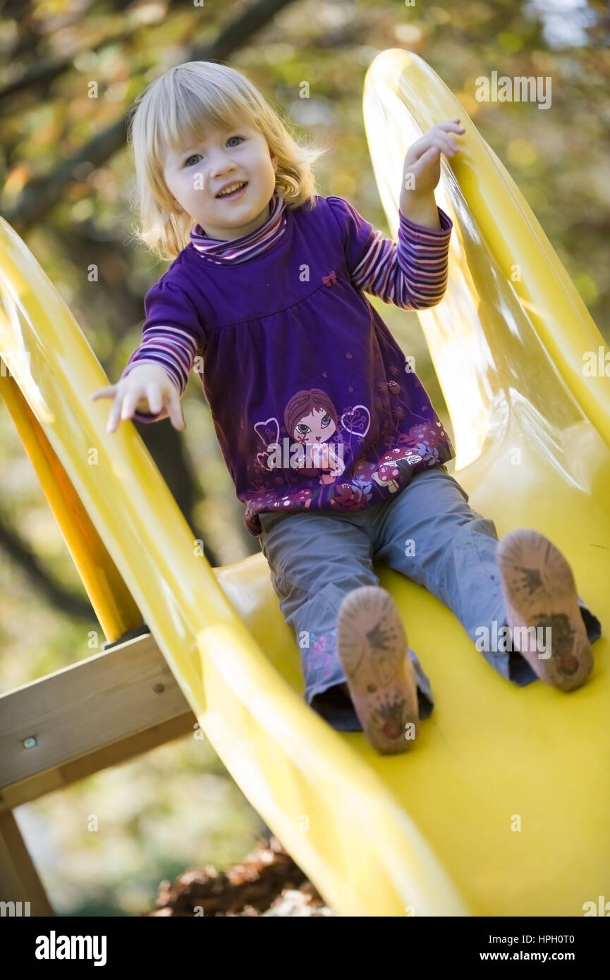 Model released , Maedchen, 3, am Kinderspielplatz auf der Rutsche - little girl on playground Stock Photo