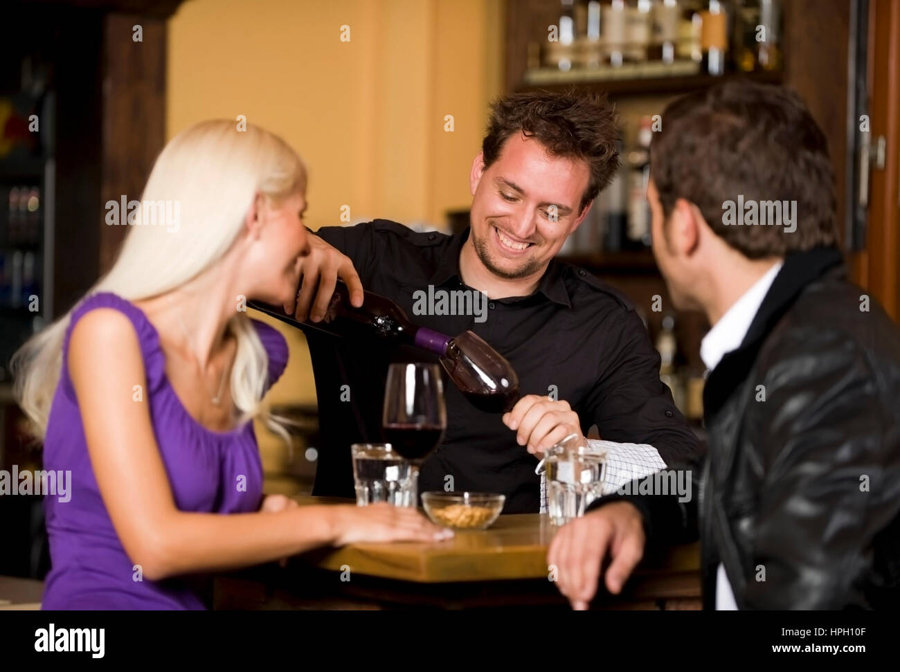 Model released , Paar und Kellner an der Theke - couple and waiter at the bar Stock Photo