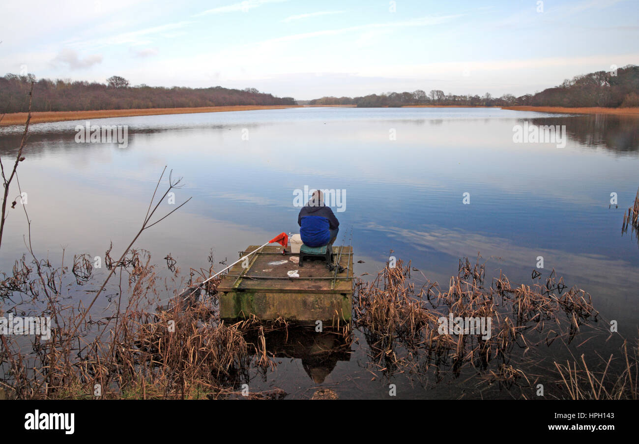 A view of Ormesby Broad on the Norfolk Broads with an angler in the