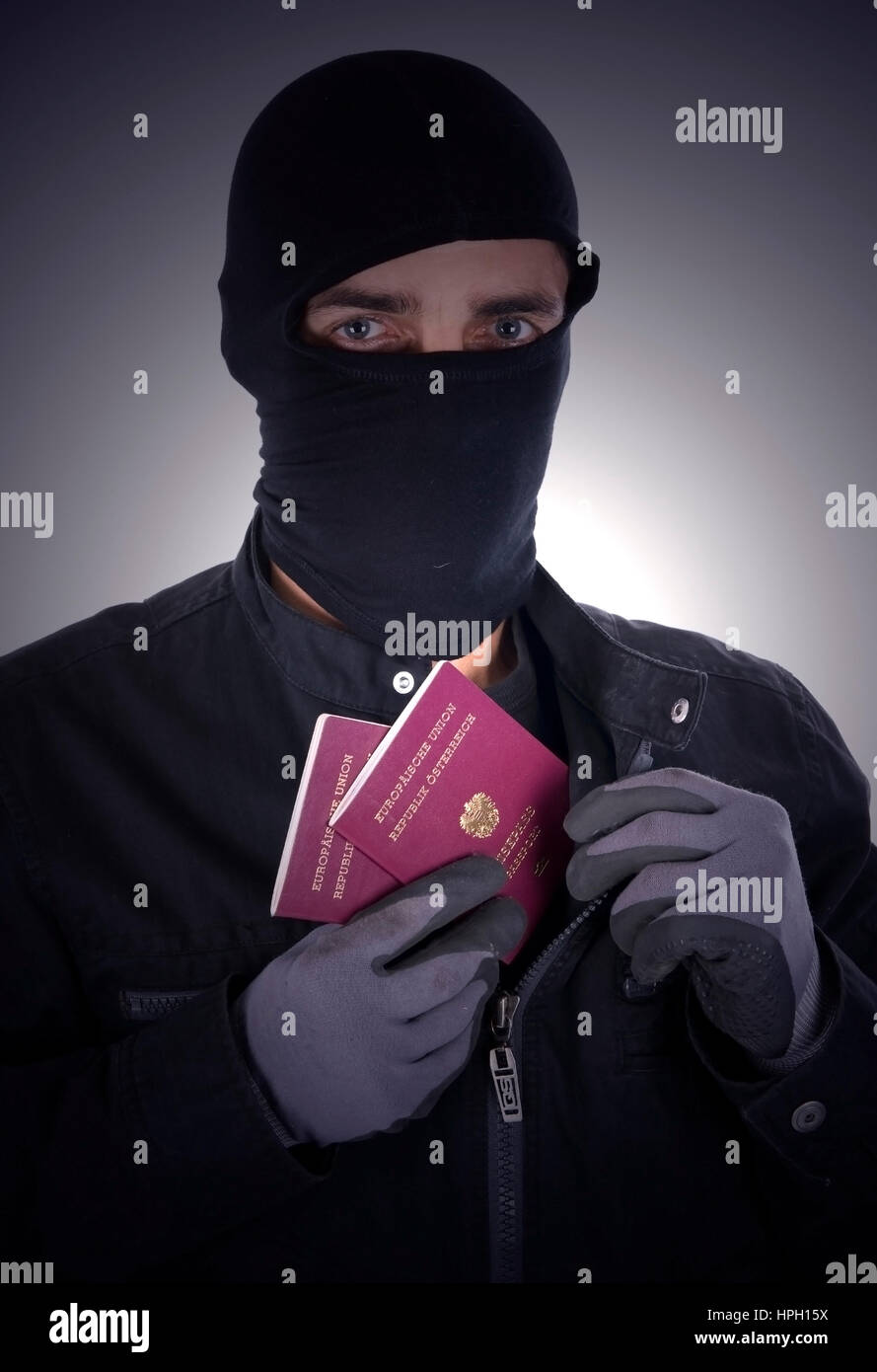 Model released , Symbolbild Illegaler Einwanderer, Mann mit Gesichtsmaske und Reisepass - symbolic for illegal immigrant Stock Photo
