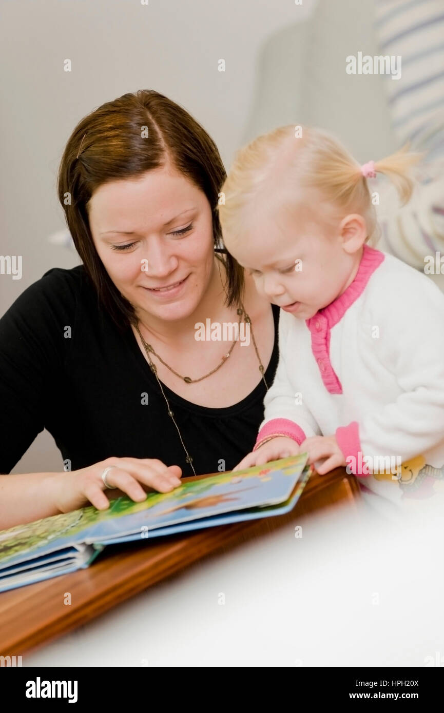 Model released , Mutter und Tochter betrachten ein Kinderbuch - mother with daughter Stock Photo