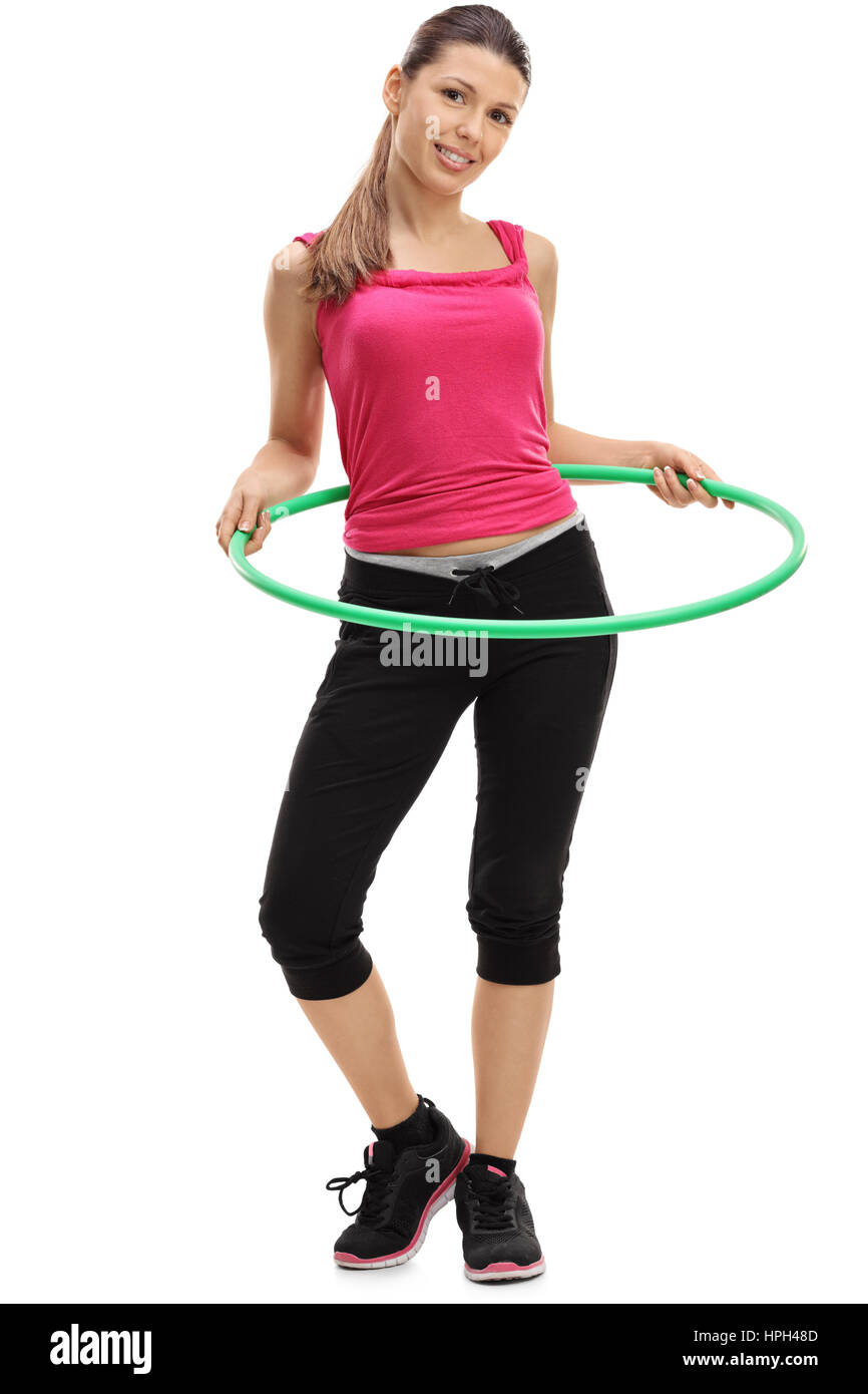 Full length portrait of a female athlete exercising with a hula-hoop isolated on white background Stock Photo