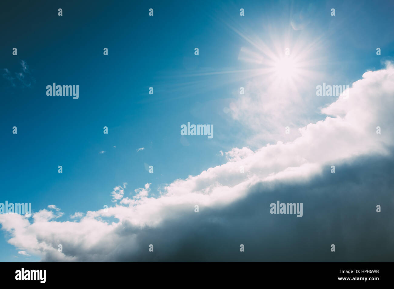 Dramatic Sky, Bright Blue And White Colors. Sun Shine Over Fluffy Clouds At Sunny Day Stock Photo