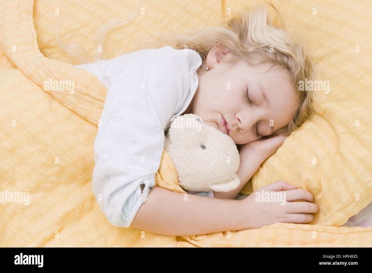 Maedchen liegt im Bett und schlaeft - girl sleeping, Model released Stock Photo