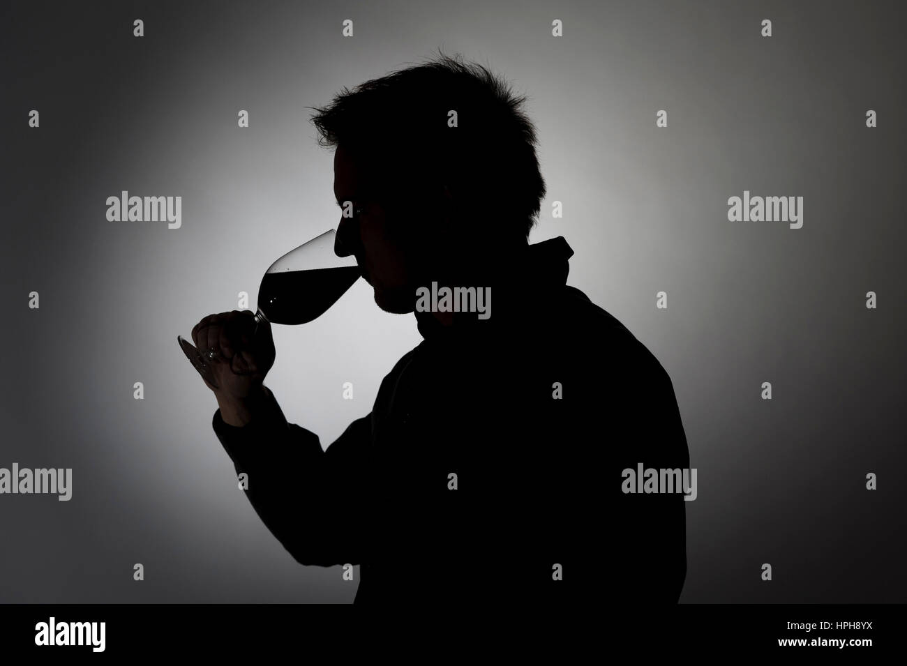 Mann trinkt aus Weinglas, Silhouette - man drinks wine, Model released Stock Photo