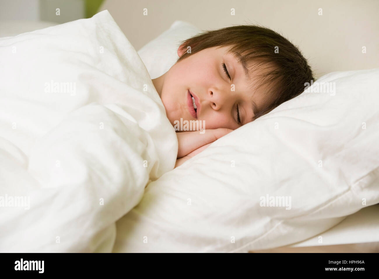 Junge schlaeft im Bett - boy sleeping, Model released Stock Photo
