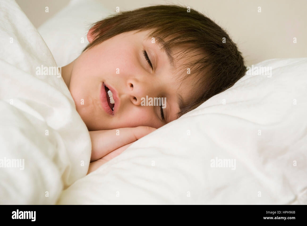 Junge schlaeft im Bett - boy sleeping, Model released Stock Photo