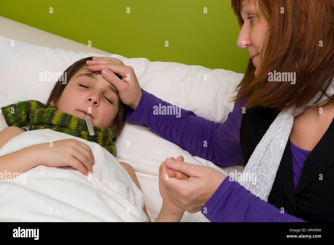 Mutter sitzt am Bett von krankem Sohn - sick son in bed, Model released Stock Photo