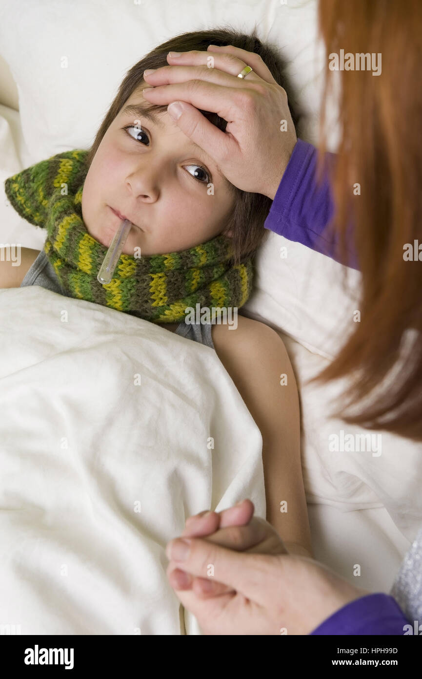 Mutter sitzt am Bett von krankem Sohn - sick son in bed, Model released Stock Photo