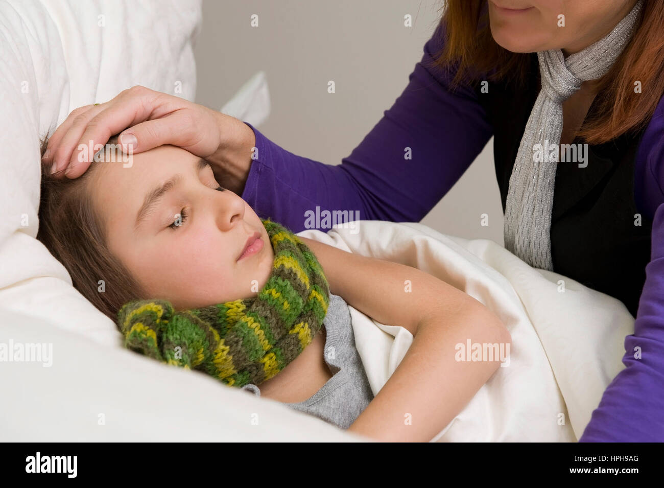 Mutter sitzt am Bett von krankem Sohn - sick son in bed, Model released Stock Photo
