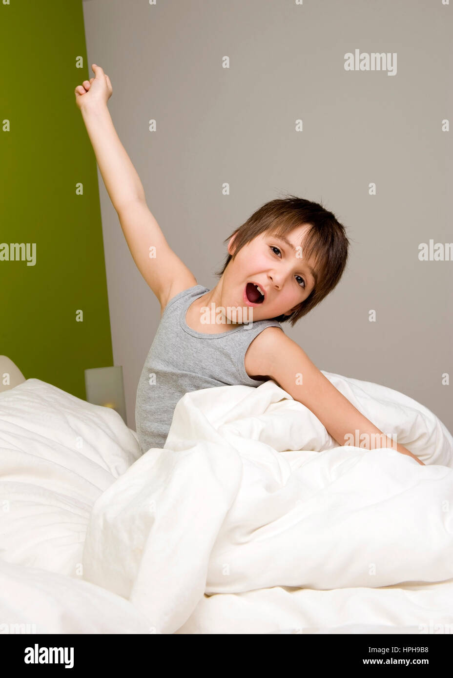 Junge reckt und streckt sich im Bett - little boy wakes up in the morning, Model released Stock Photo