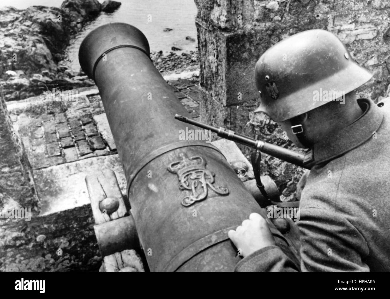 The Nazi propaganda image depicts a German soldier of the Kriegsmarine (German Navy) at a historical cannon on a British Channel Island after the occupation by the German Wehrmacht. The photo was taken in July 1940. For centuries, the Channel Islands served as stepping-stone for violent attempts to interfere in politics of the continental states. Therefore, the islands were accordingly developed as fortifications. Photo: Berliner Verlag / Archive - NO WIRE SERVICE -  | usage worldwide Stock Photo