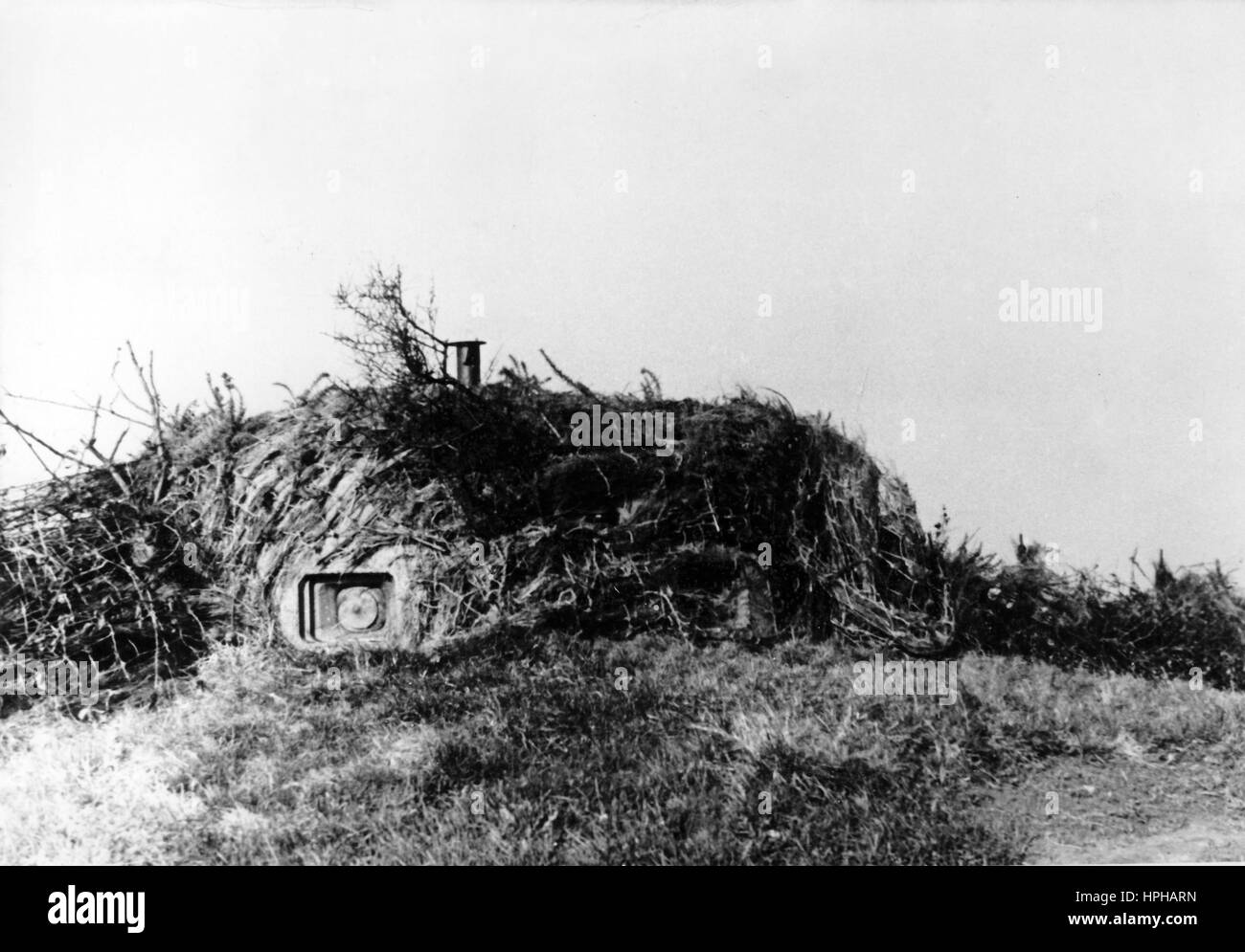 The Nazi propaganda image shows a bunker on the Atlantic Wall. Published in December 1943. A Nazi reporter has written on the reverse of the picture, 'A masterpiece: the Atlantic Wall. An inconspicuous hedge cutting through farmland. Who would suspect that within it lies a defense base, that can open up and fire in all directions. If you look closely, you can make out the opening of a 6-embrasure turret with the muzzle of a heavy machine gun and a panoramic telescope, which - like a periscope on a u-boat - allows observation from every side. Fotoarchiv für Zeitgeschichte - NO WIRE SERVICE - Stock Photo