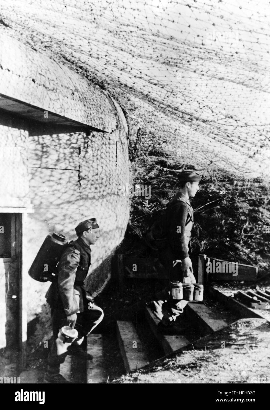 The Nazi propaganda image shows German Wehrmacht food carriers supplying front-line posts on the Atlantic Wall of the French Channel coast. Published in January 1944. A Nazi reporter has written on the reverse of the picture on 06.01.1944, 'On the front-line posts on the Channel. The food for the base camp crew has to be collected from the village 4km away. In the meantime the comrades in the bunker keep the look-out for the enemy.' Fotoarchiv für Zeitgeschichte - NO WIRELESS SERVICE - | usage worldwide Stock Photo