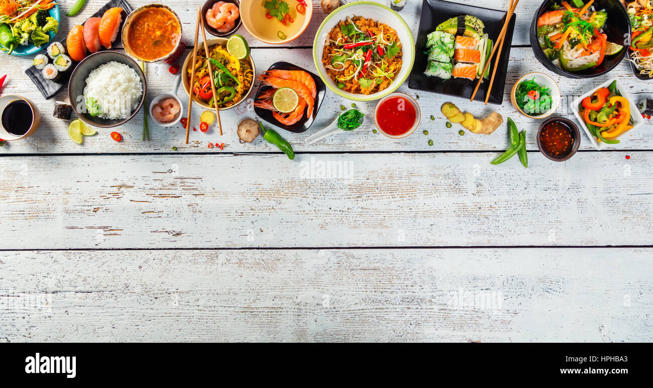 Asian food served on white wooden table, top view, space for text. Chinese and vietnamese cuisine set. Stock Photo