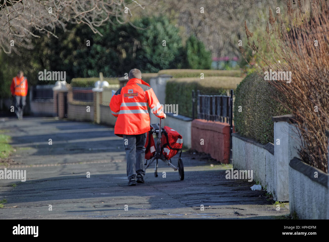 Royal Mail postman delivering letters with trolly Stock Photo