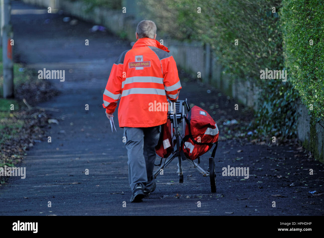 Royal Mail postman delivering letters with trolley Stock Photo