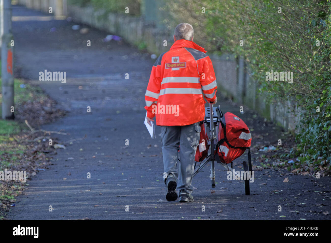 Royal Mail postman delivering letters with trolly Stock Photo