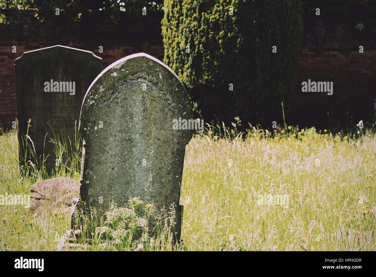 Grave stones outside a church in Beaconsfield, Buckinghamshire, England Vintage Retro Filter. Stock Photo