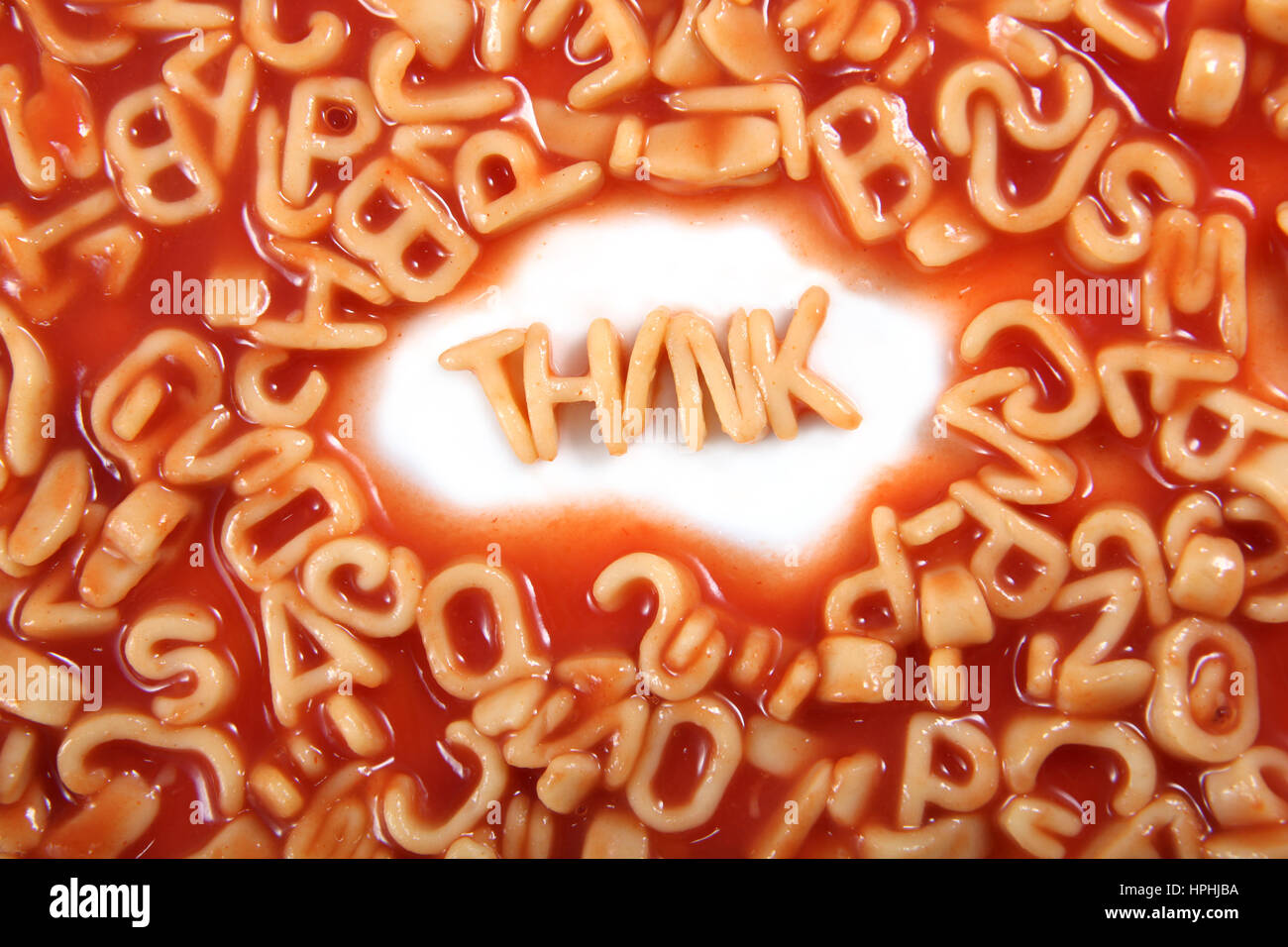 Think written in spaghetti pasta letters surrounded with jumbled letters. Stock Photo