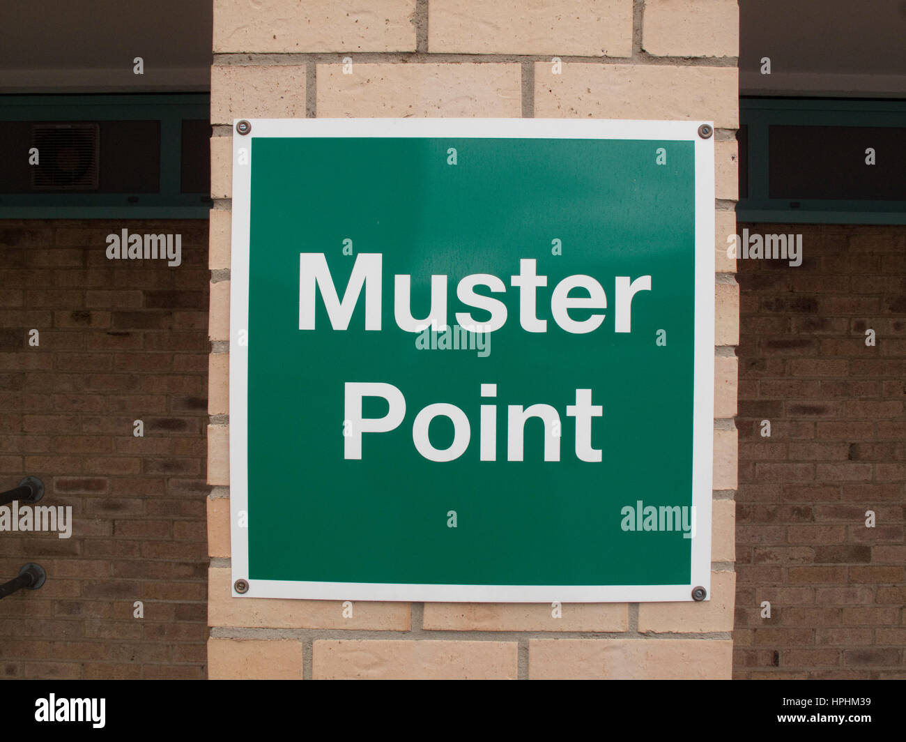 Green muster point sign on a brick pillar Stock Photo
