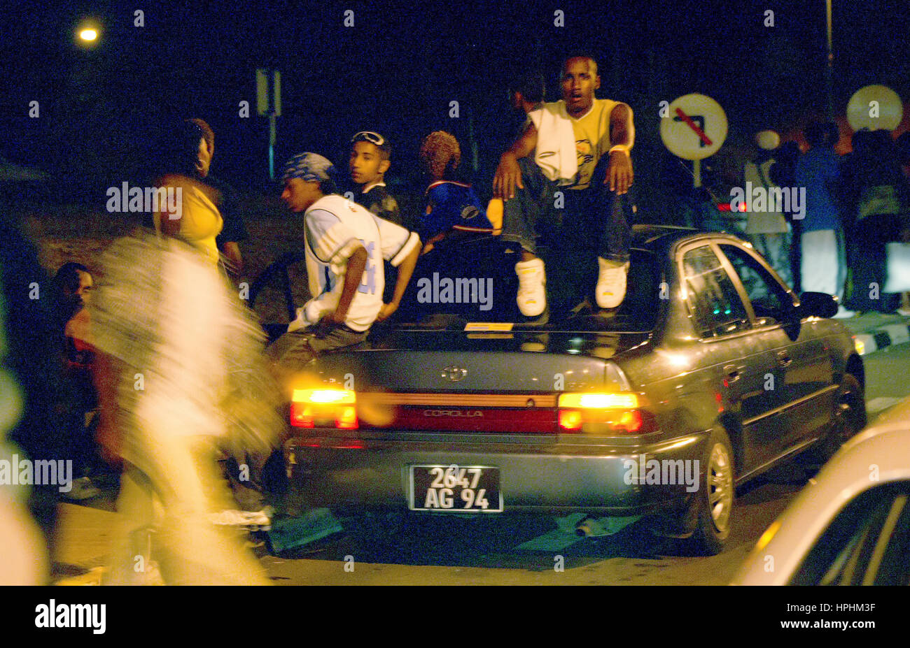 Mauritius, young Mauritians on the street waiting for admission in a disco, teenagers in front of their car, teenager, young men from Mauritius waitin Stock Photo
