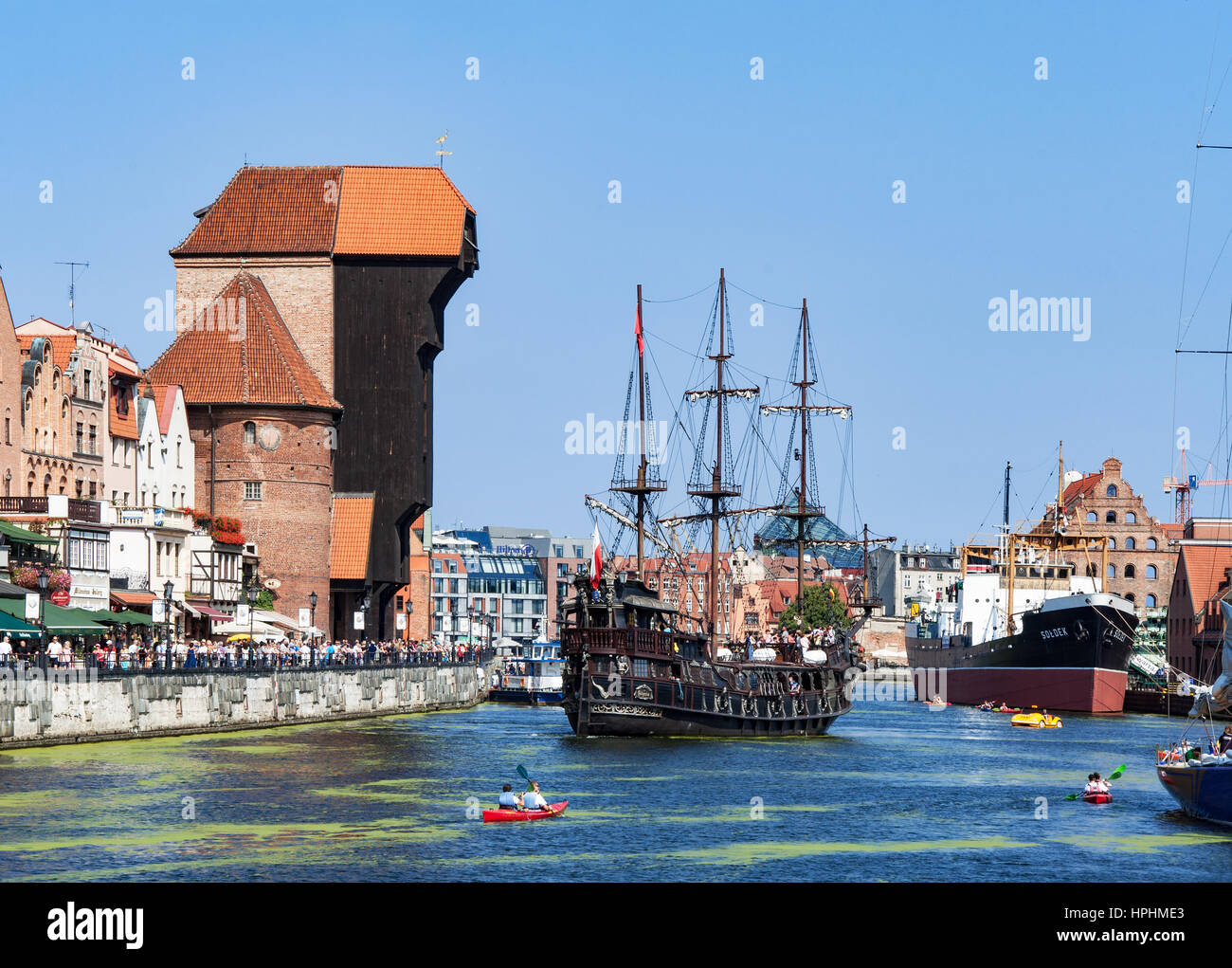 GDANSK, POLAND – AUGUST 27, 2016: Old city with medieval wooden port crane, the oldest in Europe,  Motlava river, tourist pirate ship, boats, kayaks a Stock Photo