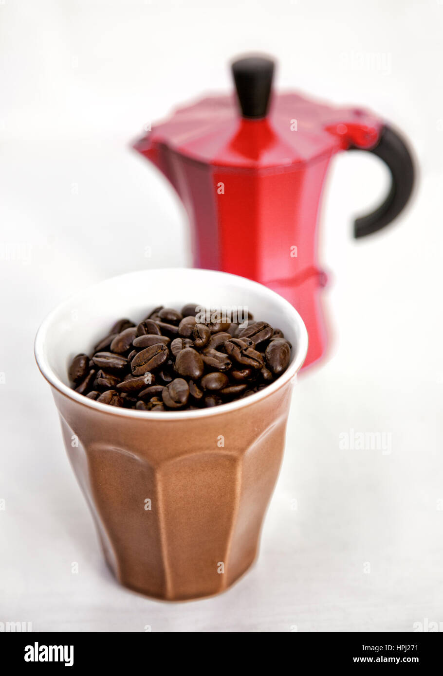 A cup of coffee beans and a stove top coffee maker Stock Photo Alamy