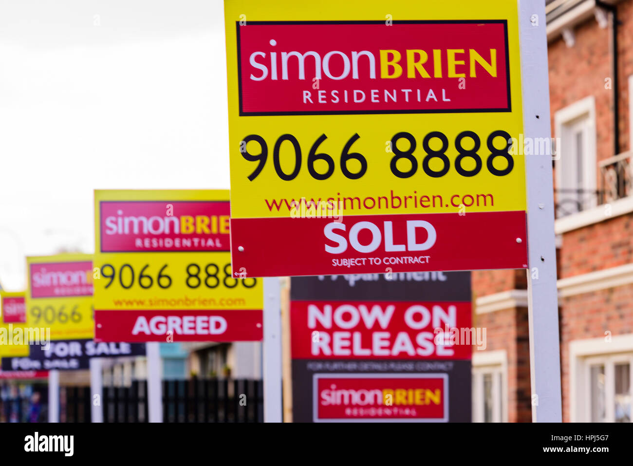 Row of Estate Agent's For Sale signs with 'Sold', 'Agreed' and 'For Sale'. Stock Photo