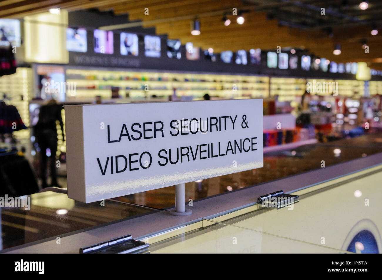 Sign at a duty free shop warning that laser security and video surveillance are in place. Stock Photo