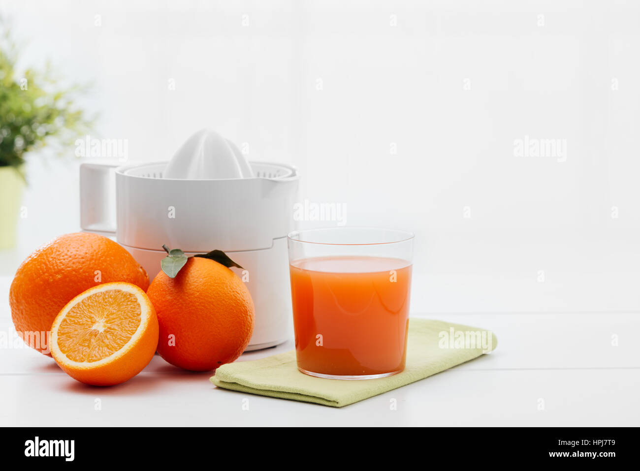 Female hand squeezing orange juice from fresh oranges with a juicer in the  home kitchen, ?lose up Stock Photo - Alamy