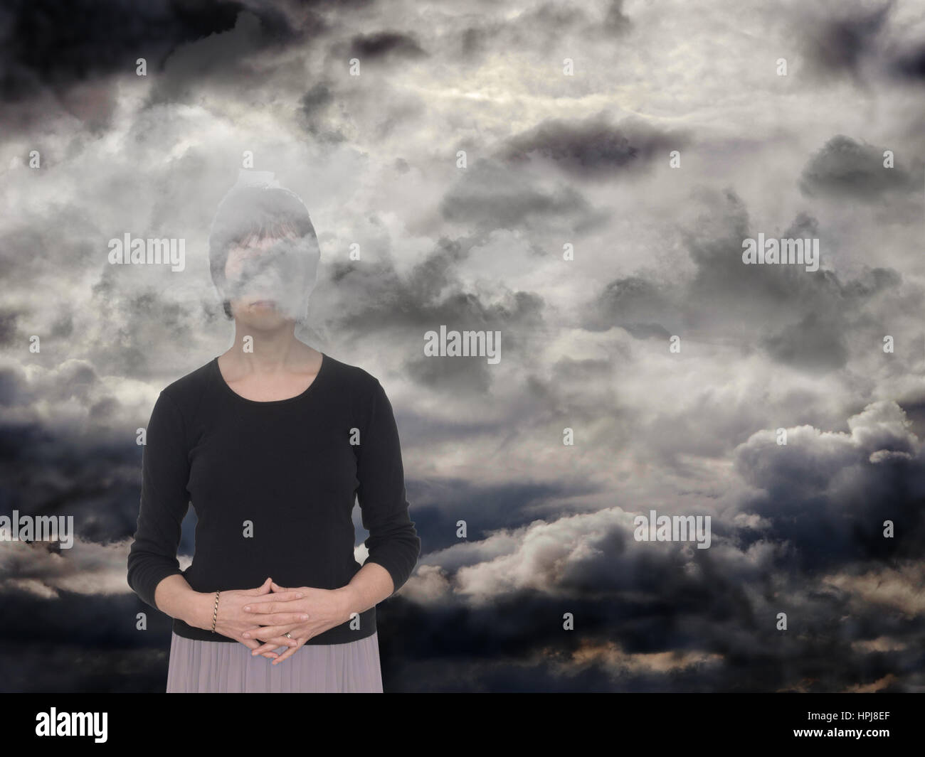 Woman in a dark space, grey clouds. Depression, anxiety concept, metaphor. Stock Photo