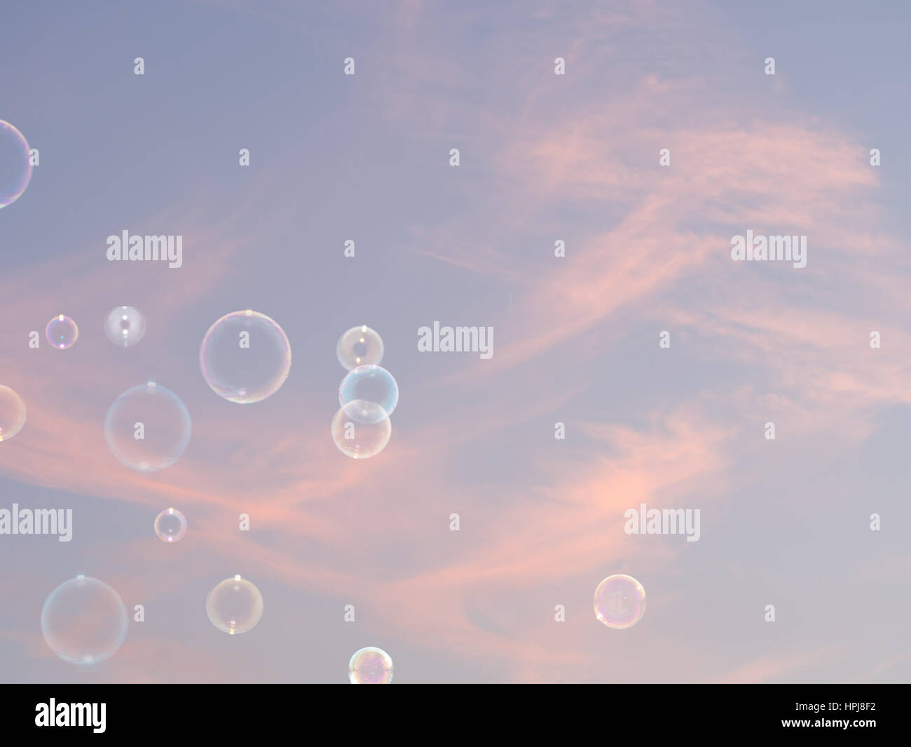 Soap bubbles and sky. Pink sunset clouds. Delicate background, light airy,gentle concept. Stock Photo