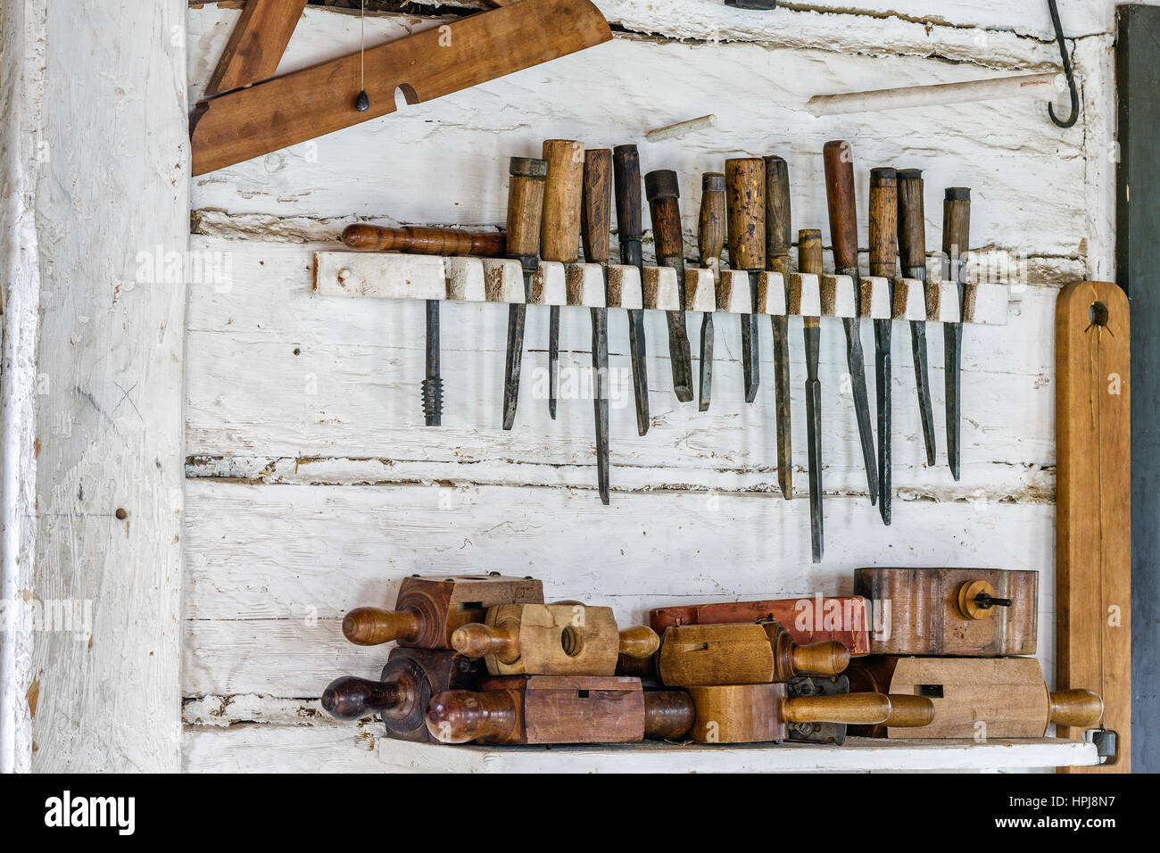 Vintage carpentry tools hanging on wall. Stock Photo