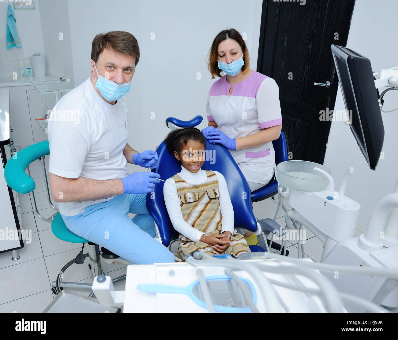 portrait of an African baby girl with black skin in the dental chair ...