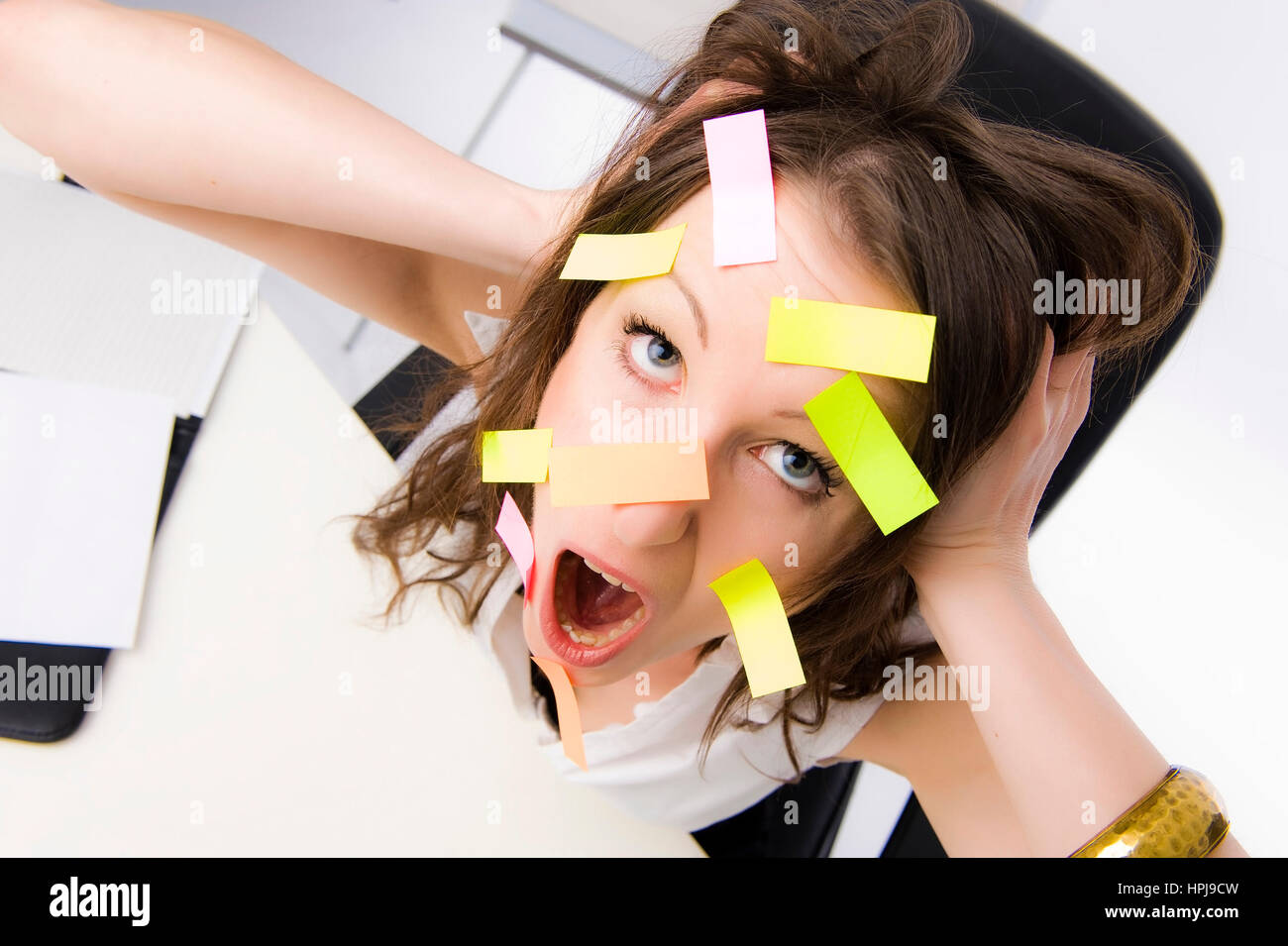Model released , ‹berforderte Bueroangestellte mit vielen Post-Its im Gesicht - overworked clerk with many post-its on the face Stock Photo