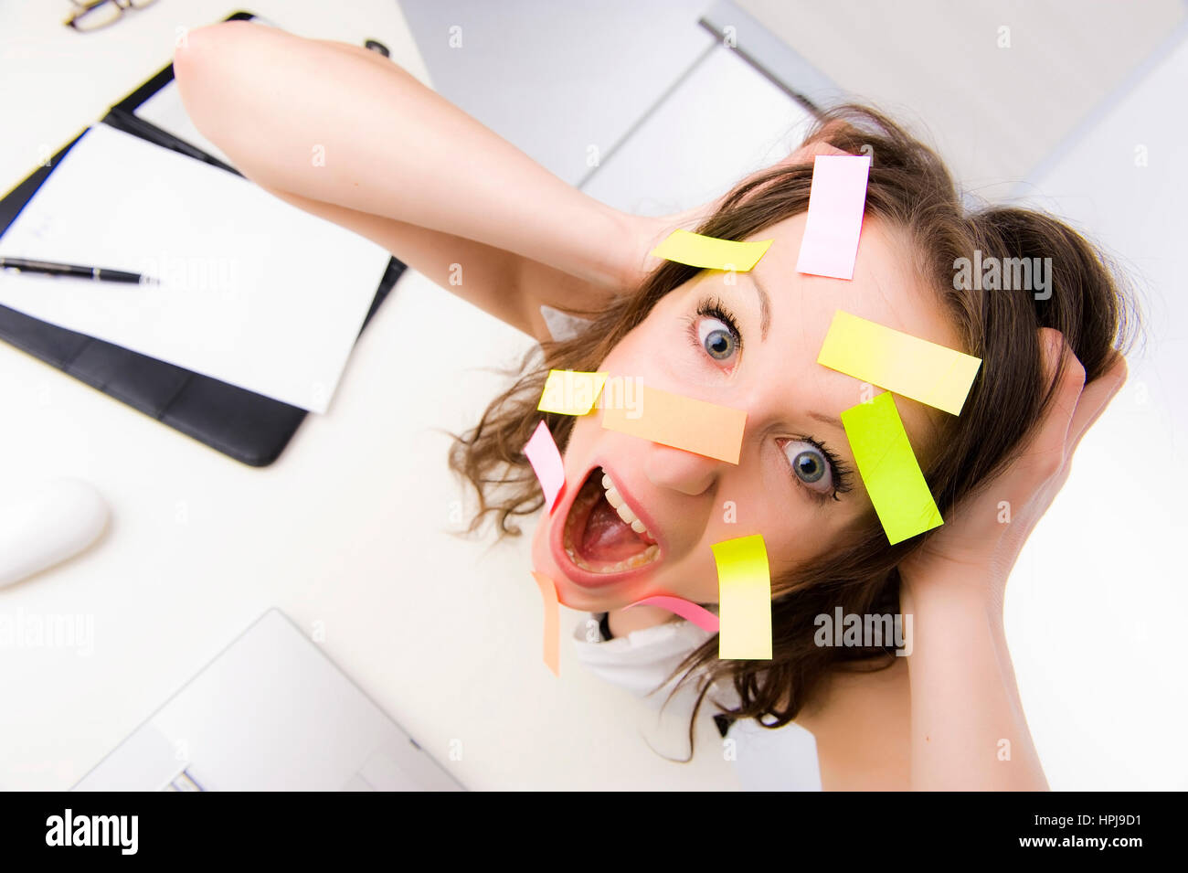 Model released , ‹berforderte Bueroangestellte mit vielen Post-Its im Gesicht - overworked clerk with many post-its on the face Stock Photo