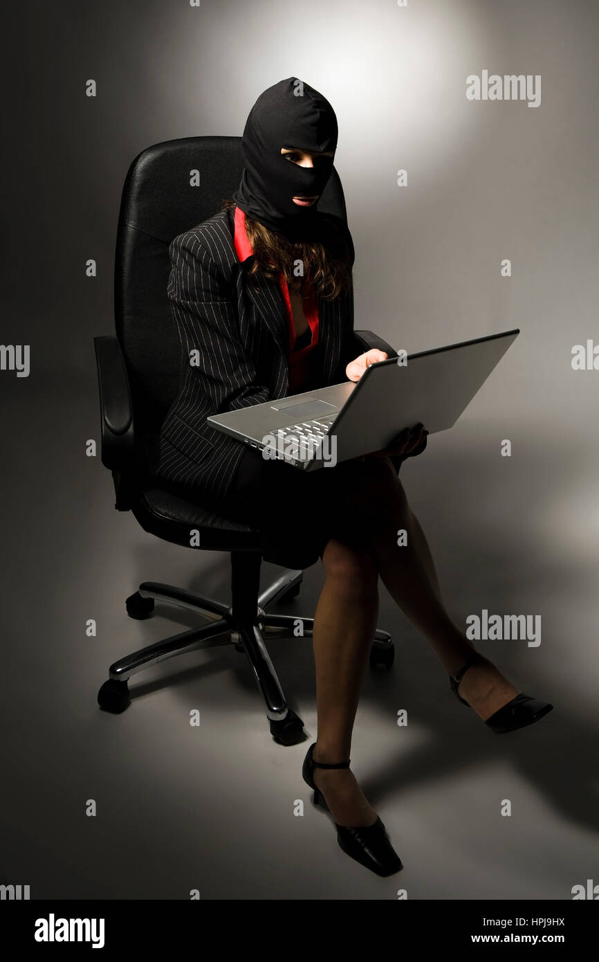 Model released , Einbrecherin mit Laptop, Wirtschaftsspionage - symbolic for data piracy Stock Photo