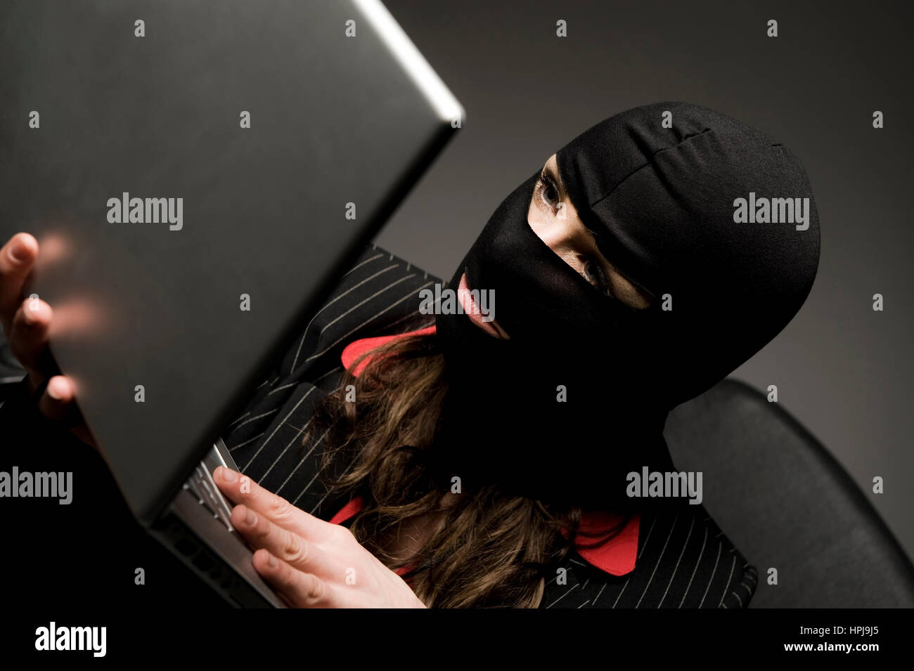 Model released , Einbrecherin mit Laptop, Wirtschaftsspionage - symbolic for data piracy Stock Photo