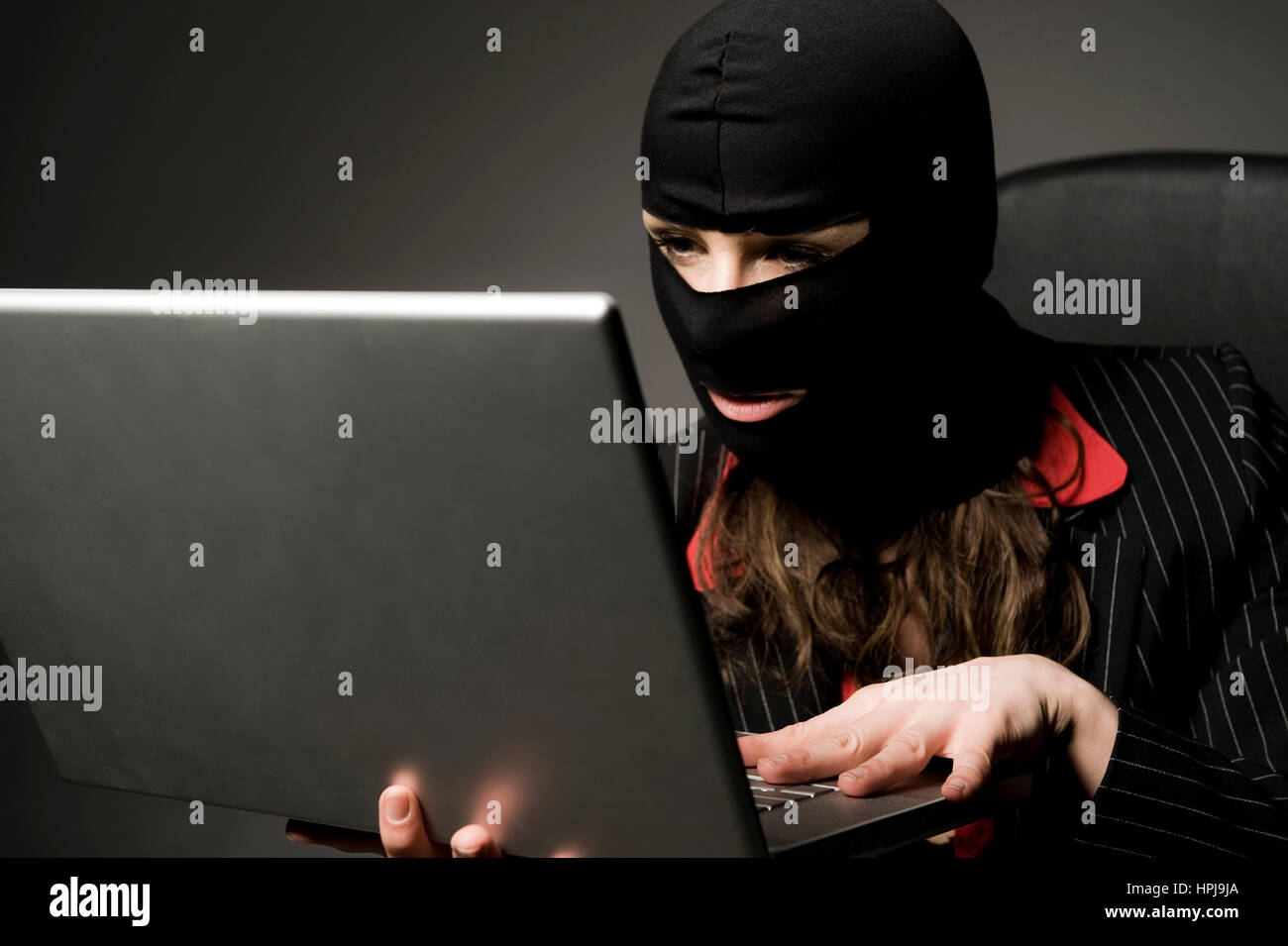 Model released , Einbrecherin mit Laptop, Wirtschaftsspionage - symbolic for data piracy Stock Photo