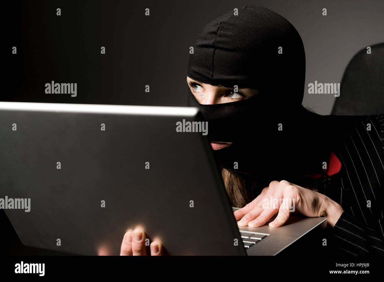 Model released , Einbrecherin mit Laptop, Wirtschaftsspionage - symbolic for data piracy Stock Photo