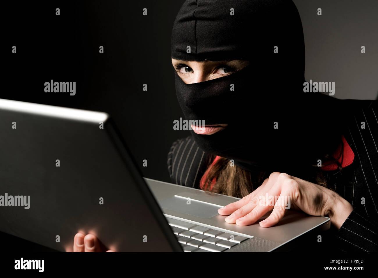 Model released , Einbrecherin mit Laptop, Wirtschaftsspionage - symbolic for data piracy Stock Photo